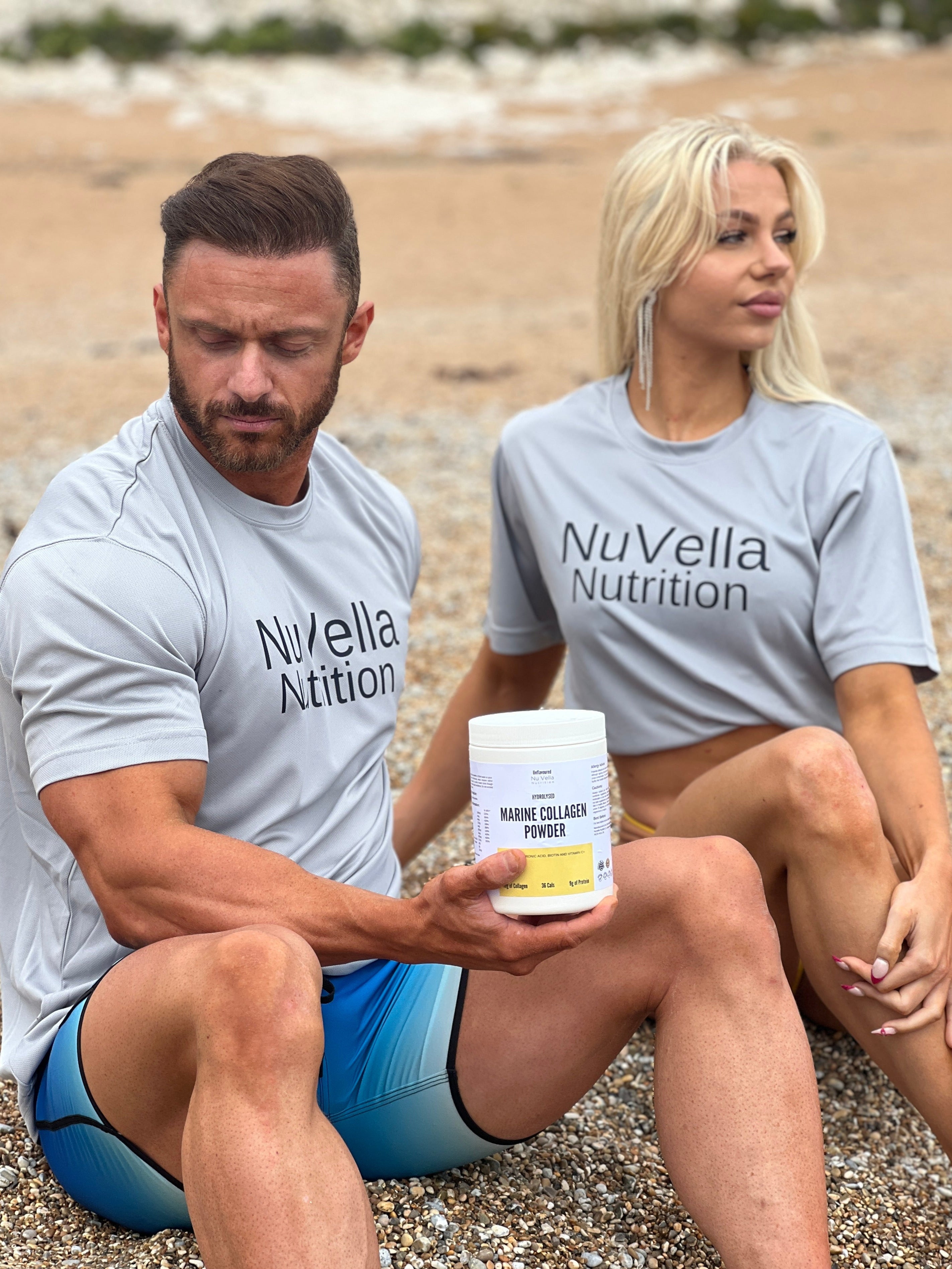 Two people sitting on a beach, one holding a container of NuVella Nutrition product.